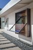 Modern home with Walkways, Concrete Patio, Porch, Deck, Metal Patio, Porch, Deck, Outdoor, and Front Yard. A custom rain-gutter system collects even slight amounts of precipitation in an underground cistern and distributes it to the yard. The Cor-Ten pivoting window is by Brian Linn of Vincent Designs. Photo 3 of The Krohn/Koza Residence