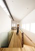 Modern home with Hallway and Light Hardwood Floor. A bridge links the living area to the kitchen. Photo 4 of Dogpatch Cottage