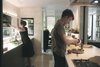 Modern home with Hardscapes, Stone Patio, Porch, Deck, Kitchen, and Shrubs. Sarah and her sons prepare a meal in the kitchen, which the Wessels recently upgraded with Bulthaup cabinets, counters, and sink. The stovetop is from Gaggenau and the faucet is from Dornbracht. On the far wall is one of Yoshitomo Nara’s signature eye-patch portraits. Photo 4 of Wessel Residence