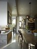Modern home with Shrubs, Kitchen, Stone Patio, Porch, Deck, Concrete Counter, and Hardscapes. In the dining area, chairs found in an antique store join a table the Wessels made from a piece of mesquite. Overhead is Lindsey Adelman's Branching Bubble fixture. Photo 5 of Wessel Residence