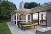 Modern home with Outdoor, Back Yard, Stone Patio, Porch, Deck, Grass, and Large Patio, Porch, Deck. “This is not a custom home—it’s the case of a builder who put something up in D.C. catering to a more traditional market,” explains Balodemas. “He framed the ceilings down to make them symmetrical. It would’ve been weird at that time to have the rooms oddly shaped. People were way too timid back then.” The rear terrace features new pavers from Pennsylvania Blue Slate and Crate and Barrel seating. Photo 7 of The Bruning/Owen Residence