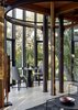 Modern home with Dining Room, Table, Chair, and Medium Hardwood Floor. The tree house–inspired design mimics the surrounding woods. On each floor, steel rings and columns support Western red cedar floor joists above. Photo 4 of Paarman Tree Home