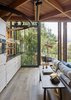 Modern home with Kitchen, Medium Hardwood Floor, Drop In Sink, Ceiling Lighting, and Wood Cabinet. The kitchen features elm cabinets made by Valcucine in Italy. Photo 5 of Paarman Tree Home