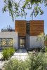 Modern home with Outdoor, Shrubs, Grass, Hardscapes, Front Yard, Gardens, and Walkways. The designers used wood sparingly for maximum effect, like the cedar siding on the front and back exteriors. The main facade offers a glimpse through the house to the backyard, which was made larger by placing the garage closer to the street. “We hosted a concert and had people sitting inside and in front of the pool,” says Jaclyn. “The house completely lends itself to entertaining small and large groups alike.” Photo 11 of Walnut House