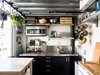 Modern home with Kitchen, Metal Counter, Microwave, and Drop In Sink. The kitchen, located behind the stairs and underneath Max’s bedroom, is all electric, with two burners, a rice cooker, a slow cooker, and a toaster oven. Max added industrial shelving and a butcher block. “Vertical storage,” he notes, “is very important.” Photo 7 of Max's Apartment