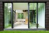 Modern home with Windows and Sliding Window Type. The interior is spare and modern. The cabinets and chairs are from IKEA. So is the table, which has a DIY laminated-ash top. Suzanne Rochon bought the cabin in 2002 and spent a decade fixing it up before calling on YH2 Architecture. In 2005, she added five acres, doubling the property. Photo 9 of La Colombière