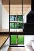 Modern home with Hallway and Light Hardwood Floor. The second floor is a master bedroom, bathroom, and mechanical room, along with an open volume that fills the house with light from the Alumilex doors and windows. The paint is Distant Gray by Benjamin Moore. Photo 7 of La Colombière