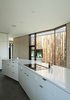 Modern home with Kitchen, Concrete Floor, Cooktops, White Cabinet, and Drop In Sink. In the kitchen, the cabinetry is by High Country Cabinets and the countertop is Caesarstone. Photo 9 of Friesen-Wong Residence
