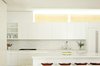 Modern home with Kitchen, Marble Backsplashe, White Cabinet, Wall Lighting, Marble Counter, Drop In Sink, and Refrigerator. The kitchen is defined by Olympian White Danby marble counters and backsplash by Stone Source. The Tractor stools are by Craig Bassam for BassamFellows. Photo 5 of The Ro Residence