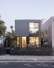 Modern home with Hardscapes, Front Yard, Trees, Large Patio, Porch, Deck, Vertical Fences, Wall, Exterior, House Building Type, Metal Siding Material, and Flat RoofLine. Universal design and affordability were uppermost in the minds of TJ Hill and Jay Heiserman when they asked Jared Levy and Gordon Stott of Connect Homes to replace their cramped bungalow with a modern prefab. Since the firm’s modules are eight feet wide, the house could only be 16 feet wide, but the architects used the remaining space for a large deck, creating a flexible and seamless first-floor plan. Photo of Hill-Heiserman House
