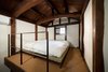 Modern home with Bedroom, Bed, and Carpet Floor. The second floor bedroom is surrounded by clay walls. A tatami and futon provide sleeping quarters for two people; a mattress is available, too. Photo 9 of Nichinichi Townhouse