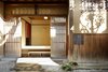 Modern home with Outdoor, Garden, Walkways, and Hardscapes. Fukuoka-based firm CASE-REAL executed a renovation of the century-old residence in 2015, creating functional zones that would serve their clients' lifestyles and accommodate guests: a tea room, gallery space, office, and guest room. The modern aesthetics of the townhouse are surrounded by the thick, clay walls of a traditional Japanese warehouse, a rarity in historic memory in the neighborhood. The thoughtfully detailed interior make for quiet, comfortable spaces that evoke a calming energy and look out at seasonal environments. Photo 4 of Nichinichi Townhouse