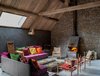 Modern home with Living Room, Chair, Concrete Floor, Rug Floor, Standard Layout Fireplace, Wood Burning Fireplace, Sofa, Floor Lighting, and Coffee Tables. The property has a soaring sense of space thanks to the vaulted ceilings. Photo 5 of La Micheline