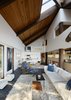 Modern home with Living Room, Rug Floor, Recessed Lighting, Recliner, End Tables, Ottomans, Track Lighting, Coffee Tables, and Sofa. Openings in the ceiling allow sunlight to wash over the black slate floors and fir columns. A velvet-upholstered Mr. Chair by George Mulhauser adds color to the living room. Photo 4 of Haiku House