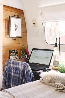 Sheena's workspace is near their bed at the front of the trailer, while Jason's work area is separately located toward the back of Mavis. 