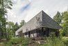 Modern home with Exterior, House Building Type, Wood Siding Material, Shingles Roof Material, and Shed RoofLine. Vince and Adrienne Murphy’s rural retreat is clad in gray shingles and gray-stained pine. “They wanted the cottage to meld into the woods and be visually quiet,” says architect Kelly Doran, who worked with Portico Timber Frames to build the 2,500-square-foot home. Photo of House on Lake Havelock