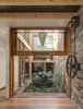 Modern home with Outdoor, Gardens, and Garden. A counterweight pulley system makes easy work of lifting the large glazed walls flanking the courtyard. Photo 3 of Aquas Perma Solar Firma