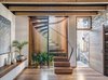Modern home with Staircase, Wood Tread, and Wood Railing. A cylindrical glass staircase with Western red cedar and painted steel mullions dominates the front of the house.The stair treads, along with the floor, are made of recycled spotted gum. Photo of Aquas Perma Solar Firma