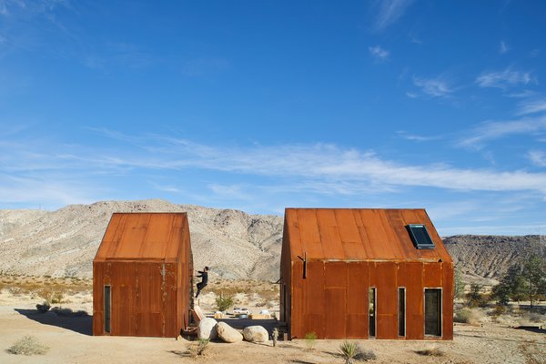 At first glance, the Folly cabins may appear to be a pair of abandoned sheds, left to rust amidst the desert landscape. Within their walls, however, is a modern dwelling swathed in raw plywood with a living space, dining area, kitchen, bathroom, and sleeping mezzanine. A soaking tub anchors a wooden deck; and just up the stairs is a stargazing portal. The off-grid cabins were created by architectural designer Malek Alqadi, who has a penchant for sustainable living.