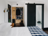 Modern home with Bedroom, Bed, Dark Hardwood Floor, Night Stands, Ceiling Lighting, Wall Lighting, and Shelves. Planked with reclaimed wood and awash in a muted color palette with pops of navy, black and white, the King rooms invoke Scandinavian design energized by the hotel’s backcountry. Photo 5 of Eastwind Hotel & Bar