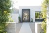 Modern home with Exterior, House Building Type, Concrete Siding Material, and Flat RoofLine. The front door was custom designed and built by Cody Carpenter, a close collaborator on The Brexley. Photo of The Brexley