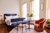 Modern home with Bedroom, Dark Hardwood Floor, Rug Floor, Bed, Night Stands, and Wall Lighting. The rooms have a private bathroom finished with colorful custom terrazzo tiles and vanity, as well as a mix of vintage and custom furniture and lighting. Photo of The Siren Hotel