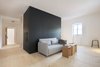 Modern home with Living Room, Light Hardwood Floor, Stools, End Tables, Table Lighting, and Sofa. The second-floor vacation suite has a convertible Softline sofa and cardboard stools from Stange Design. The storage unit is clad in black MDF. Photo 7 of Moosham 13