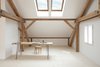 Modern home with Office, Light Hardwood Floor, Chair, and Desk. Sunlight streams into Reinhold and Verena’s loft through Velux skylights in the pitched roof. Reinhold fastened hairpin legs to an old table to create a desk, pairing it with a bentwood chair. The untreated spruce floorboards—many of which are a foot wide and 14 feet long—come from a stand of trees on the property and were milled on-site. The walls are coated in a custom lime-based paint. Photo 8 of Moosham 13