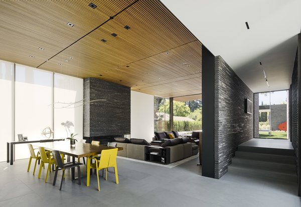 Above the custom elm dining table, a Wave pendant by Henri Bursztyn hangs from the slatted teak ceiling.