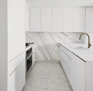 Because both Dale and Dan love to cook, and were intent on taking advantage of nearby Chelsea Market, the architect opened and significantly expanded the kitchen, adding a large counter topped by Calacatta Gold marble and installing a terrazzo tile floor with marble pieces that match the counter’s creamy tone. He designed millwork to conceal and contain heating and cooling equipment along the window wall.
