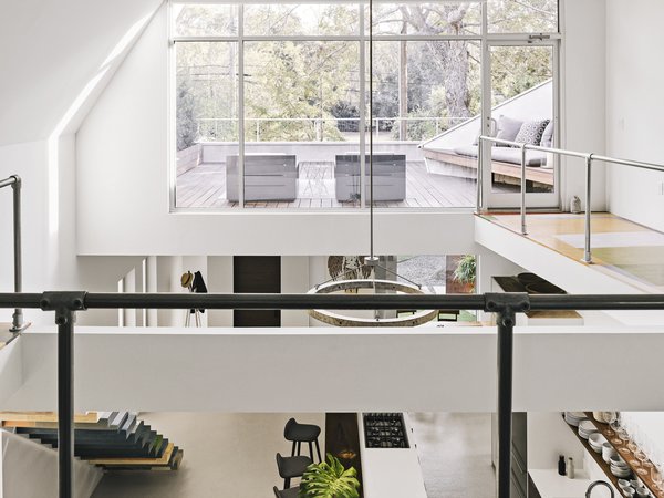 On the upper level, the master suite looks across the open space to an expansive deck.