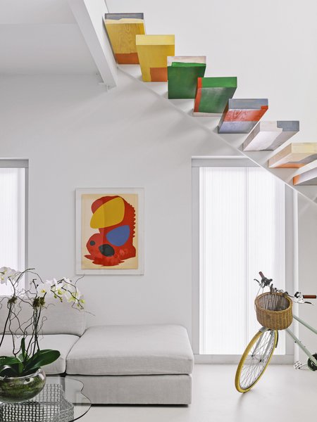 A floating wood staircase hand-painted by artist Tess Thomas  adds more than a pop of color.