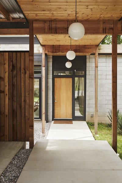 Influenced by Southern California’s Case Study House program, designer Bob Butler conceived a luminous residence and guest house on a sloping lot in Nashville that originally held a red-brick ranch-style duplex. Western red cedar lines the walkway from the carport to the entrance. The Globe lights are from West Elm.