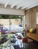 Modern home with Living Room, Chair, Coffee Tables, Table Lighting, and Sofa. An Eames lounge chair covered in Alexander Girard fabric from Maharam sits near a Girard Model 108 coffee table for Knoll. Photo 10 of The Ellison House