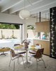 Modern home with Chair, Table, Ceiling Lighting, and Carpet Floor. DCM Molded Plywood chairs by Charles and Ray Eames for Herman Miller sit around a dining table by Eero Saarinen for Knoll. Photo 11 of The Ellison House