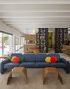 Modern home with Living Room, Chair, Table, Carpet Floor, Ceiling Lighting, Coffee Tables, and Sectional. The living area’s Chicklet sofa by Ray Wilkes is covered in a Knoll tweed. Photo 3 of The Ellison House