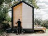 Modern home with Exterior, Wood Siding Material, Gable RoofLine, Cabin Building Type, and Metal Roof Material. A fiberglass door covers a void in the wall that holds a solar-powered water heater, a propane tank, and wood for a fire bowl. Photo 3 of Elsewhere Cabin Retreat