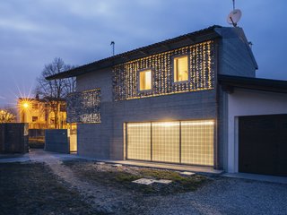 Light shines through the home's stone curtains at night.