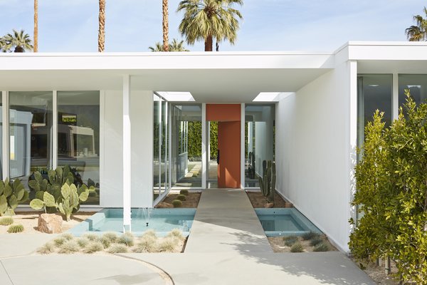 When the couple noticed tile poking out of the ground near the front door, they began excavating. To their surprise, they discovered a rectangular reflecting pool that had been buried due to neglect. Now a concrete bridge leads over the rebuilt water feature to the front door, which is painted an eye-catching orange to match its original color. 