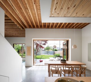Wishbone chairs by Hans Wegner for Carl Hansen & Søn surround a custom dining table, which is made out of a leftover piece of scaffolding from construction. The lighting is custom by Heather Dahl. 
