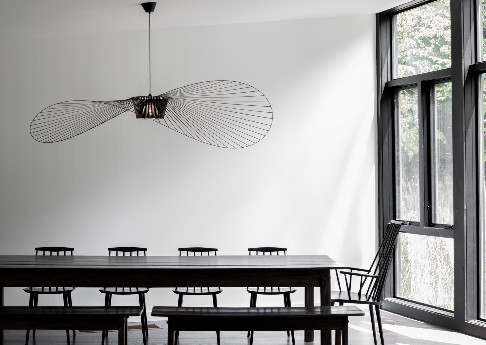 Dining Room, Table, Pendant Lighting, Chair, and Bench With Marvin floor-to-ceiling windows incorporated throughout, the home not only blurs the barriers between inside and out, it also fosters a deeper connection to nature.
