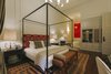 Modern home with Bedroom, Rug Floor, Night Stands, Table Lighting, Dark Hardwood Floor, Accent Lighting, Bed, Pendant Lighting, and Wall Lighting. "Malagueta," meaning chile pepper—a spice brought back to Portugal from an African voyage— is the name of this down-to-earth room with the freestanding bathtub. Photo 4 of Torel 1884 Suites & Apartments