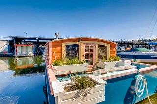 A look at the exterior of the 212-square-foot Orca houseboat. Delightfully trimmed in pink, this floating home was originally built in 1982 and received a thoughtful renovation in 2017.
