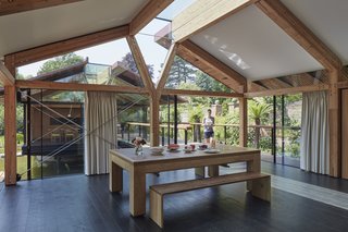 One building serves as the family's main living space, while the other holds a guest house. A bridge links the two volumes together.