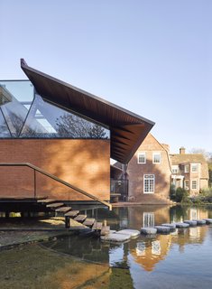 A brick facade on one of the structures relates the new buildings to the existing home, and creates the impression of a monolithic form floating effortlessly above the water.