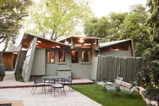 The Kallis House is known for its butterfly roof, which enabled Schindler to add clerestory windows to bring in more light. For the exterior paint, the couple ordered a custom color from Behr. "We were trying to approximate the gray-green of a Martini olive," says John.
