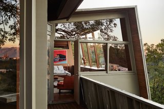 In the couple’s bedroom, a back corner window that had been straightened by the previous owner was restored to its original slant, and an interior clerestory was uncovered and used to brighten a bathroom on the other side of the wall. The vintage teak bed with built-in headboard and side tables is from Vintage on Point in Los Angeles. A signed Andy Warhol screen print hangs overhead.