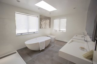 The master bath has a cool, neutral palette and a freestanding soaking tub.
