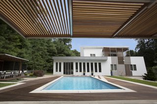 The backyard features a pristine pool and several alfresco entertaining areas shaded by cantilevering canopies.