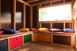 The interior was created as an open space, featuring ample storage areas and lots of pillows. The team placed several of the windows in unusual positions to provide inspiring views of the garden and covered terrace.